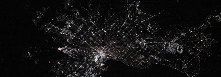 Melbourne, Australia as seen from the International Space Station at night. There are areas where city lights are concentrated. The lights are less concentrated at the edges of the image.